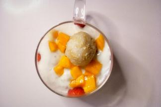 把芒果丁和藜麦饭团摆在酸奶上