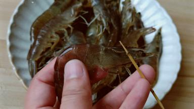 用牙签在对虾头部中间位置挑出虾线。