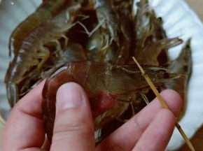 用牙签在对虾头部中间位置挑出虾线。