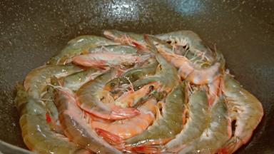 锅里加油，放对虾翻炒片刻。