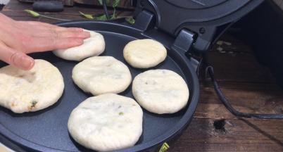 倒扣在煎饼铛盘中，压成饼