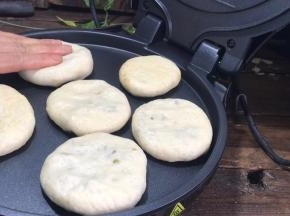 倒扣在煎饼铛盘中，压成饼