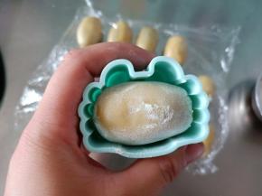 月饼在玉米淀粉中稍微滚一下，放入模具压成型