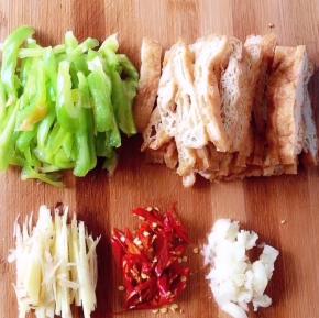 油炸干切稍宽一点的条状、青椒切稍宽条、姜切细丝、干辣椒剪成斜圈、蒜剁末