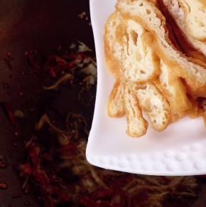 这时倒入油炸干，翻炒至均匀