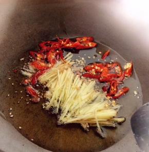 首先油锅烧热下入姜丝与干辣椒圈，稍稍炸香