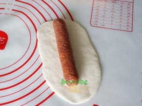 中间放入热狗并卷起来，要全部包裹好热锅，不要露出。