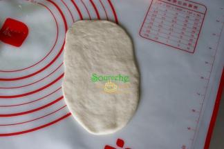 醒好的面团，中间压扁，用擀面杖擀成长条形面片，长度要根据热狗长度而定，太短，热狗会露出来。