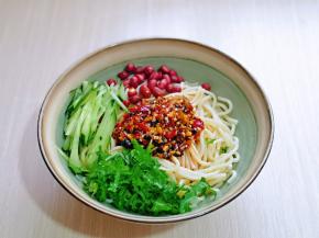 将准备好的调味汁淋在面上，加入黄瓜丝，花生米，香菜碎。