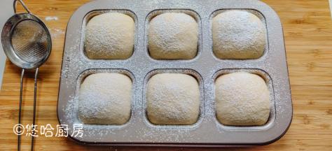 1小时后，面团发酵至满模，还高出模具一点，在面团表面筛一点大米面包粉。