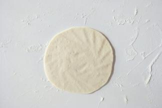 取一个小面团擀成中间厚周边薄的面皮