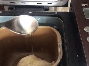 20分钟后，面团揉光滑了，加入玉米油，继续揉面40分钟左右