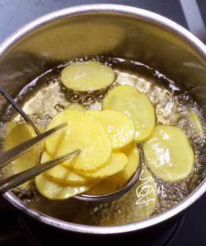 当土豆片炸熟漂浮在油面上时捞出