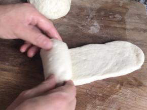 再擀一次牛舌状的面皮，在一头卷起成卷