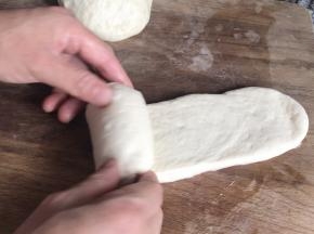 再擀一次牛舌状的面皮，在一头卷起成卷