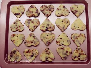 用小吸管在心型饼干上戳出一个洞，再一一摆放到学厨烤盘中。