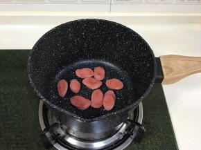 香肠切片，入锅中煎至微焦。