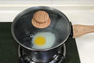 开小火，刷点食用油，往奶锅中磕入一个鸡蛋焖30秒，开盖后往鸡蛋四周撒点水滴，再次合盖，待蛋白凝固便可出锅。