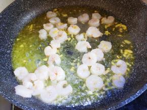 锅里油烧热放姜粒和虾仁快速翻炒。