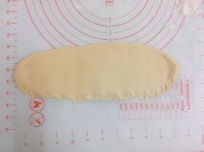 将松弛好的面团用擀面棍擀成牛舌状。