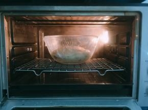 烤箱发酵模式提前预热，温度上下30度，底部烤盘加入温水来创造足够的湿度，放入面团，时间60分钟，进行基础发酵至2倍大