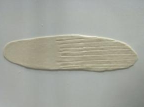 取一个小面团擀成牛舌状，其中一头用刀划几下，如图。