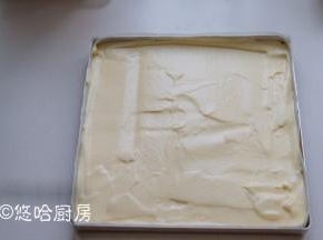 拌匀的蛋黄糊倒回余下的蛋白霜中，继续切拌均匀，拌匀的面糊呈现细腻光滑的状态。面糊倒入提前铺好油布的烤盘中，表面大致刮平，烤盘在台面上轻震几下，震出面糊中的大气泡。