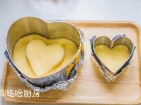 放凉的蛋糕用慕斯圈切出心型，一个6寸大的，2个小的。慕斯圈底部用锡纸包起来。