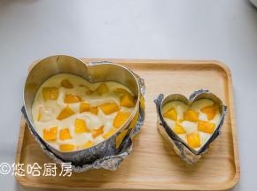 慕斯圈底部放一片蛋糕，倒入一半的慕斯液，放入一层芒果丁。保证每一块芒果丁均在慕斯液中，不要放太密。