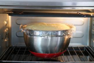 结束后将面团放入容器里揉圆，盖上保鲜膜，放入烤箱选择发酵程序开始发酵，发酵到两倍大，中间戳一个洞不回缩即可；