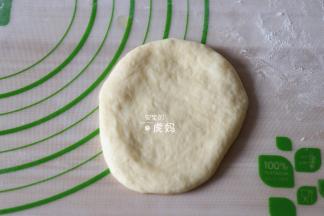 取一个面团用手压扁；