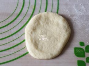 取一个面团用手压扁；