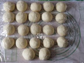 发酵完成后倒出面团揉面3-5分钟排气，然后分成50g左右的面团一一揉圆，盖上保鲜膜静置20分钟进行中间发酵；