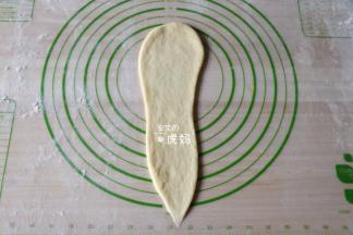 取一个面团擀成上宽下窄的长条形；
