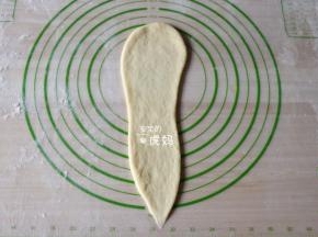 取一个面团擀成上宽下窄的长条形；