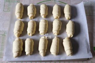 一一卷好收口朝下放入烤盘，放入烤箱进行二次发酵，发酵50-60分钟左右；