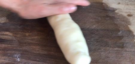 在案板上和手上抹上食用油，把面团搓成长条