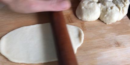 用擀面杖擀成长条，在一头卷起成卷