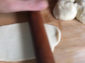 用擀面杖擀成长条，在一头卷起成卷