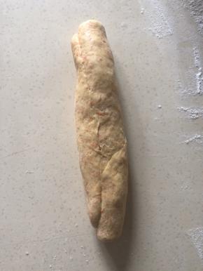 一边折上盖住红豆压紧 一层层卷起 一边卷一边压紧 尽可能卷紧 底边压紧 封口朝上