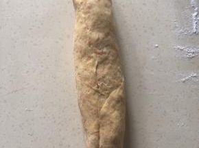 一边折上盖住红豆压紧 一层层卷起 一边卷一边压紧 尽可能卷紧 底边压紧 封口朝上