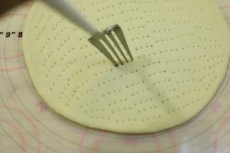 利用叉子在面皮上插上小孔。