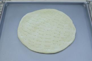 烤盘表面抹少许的植物油，放入一块披萨皮。