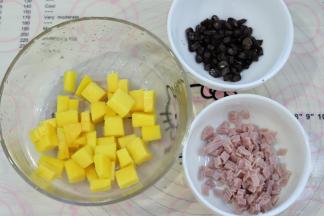 烤披萨皮的时候准备披萨材料：水果切粒，黑玉米煮熟，培根切成小块。