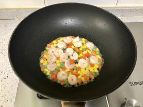 再下入解冻好的什锦蔬菜粒，翻炒片刻。