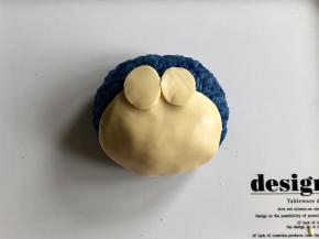 用芝士片剪出一个比饭团小一些的椭圆形做脸部，再剪两个小椭圆形做眼睛，然后如图放在饭团上。