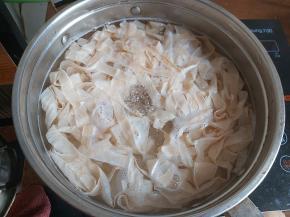 干豆皮用冷水泡干，也泡掉表面的盐，煮一锅清水，水开后下入锅内，轻轻的煮2分钟左右。