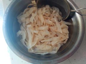 沥水后倒入冷水盆内冷却。