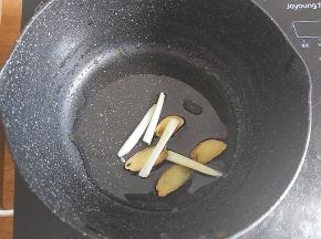 准备个小锅，倒入一大勺植物油，加入几片生姜、葱段，炸香。