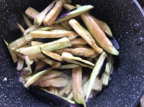 加茄子翻炒均匀，淋上调好的酱汁，盖盖子炖煮5分钟